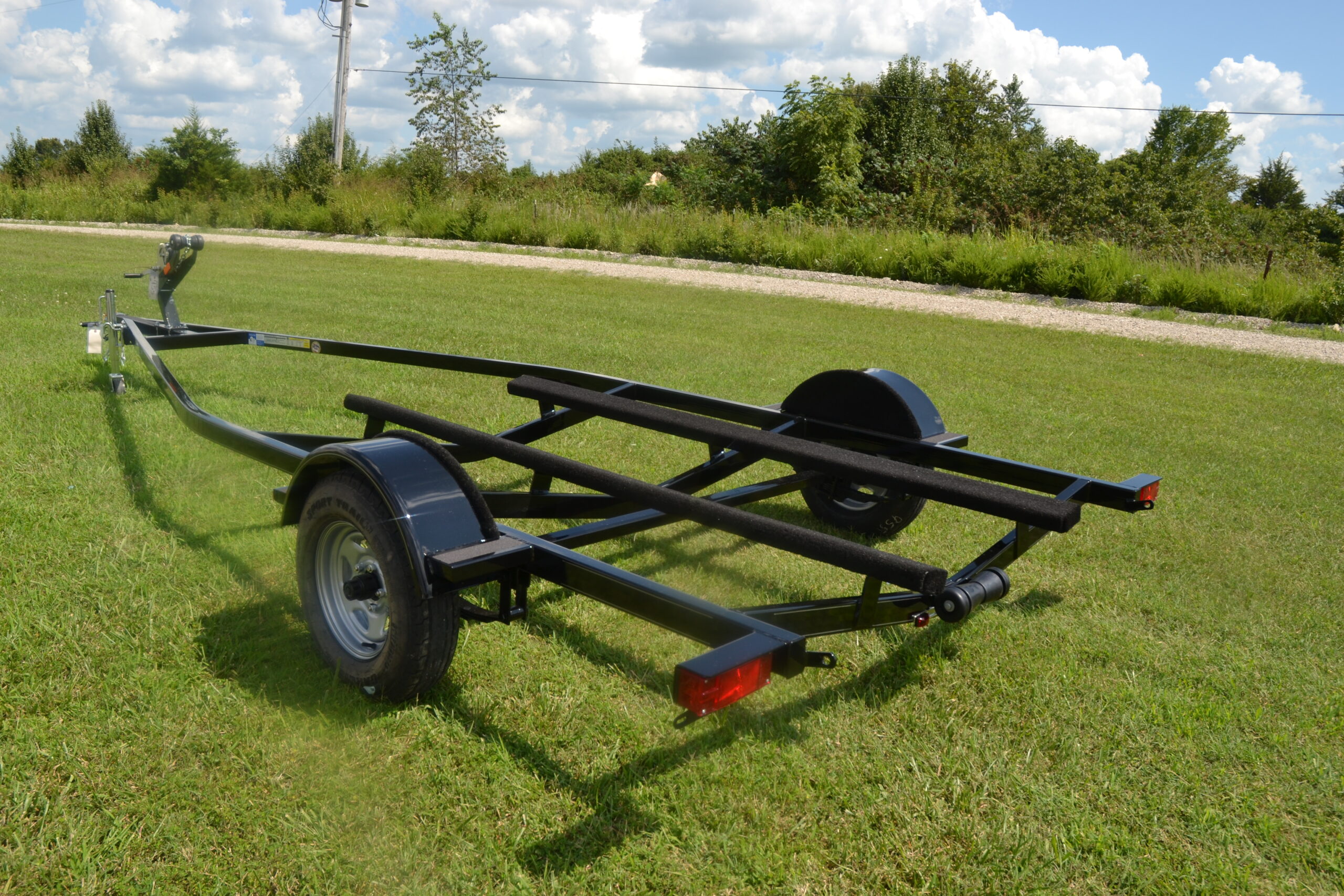 EZ Loader single axle steel boat trailer designed for V-hull boats, featuring a durable painted steel frame, carpeted bunks, and fender-mounted step plates.