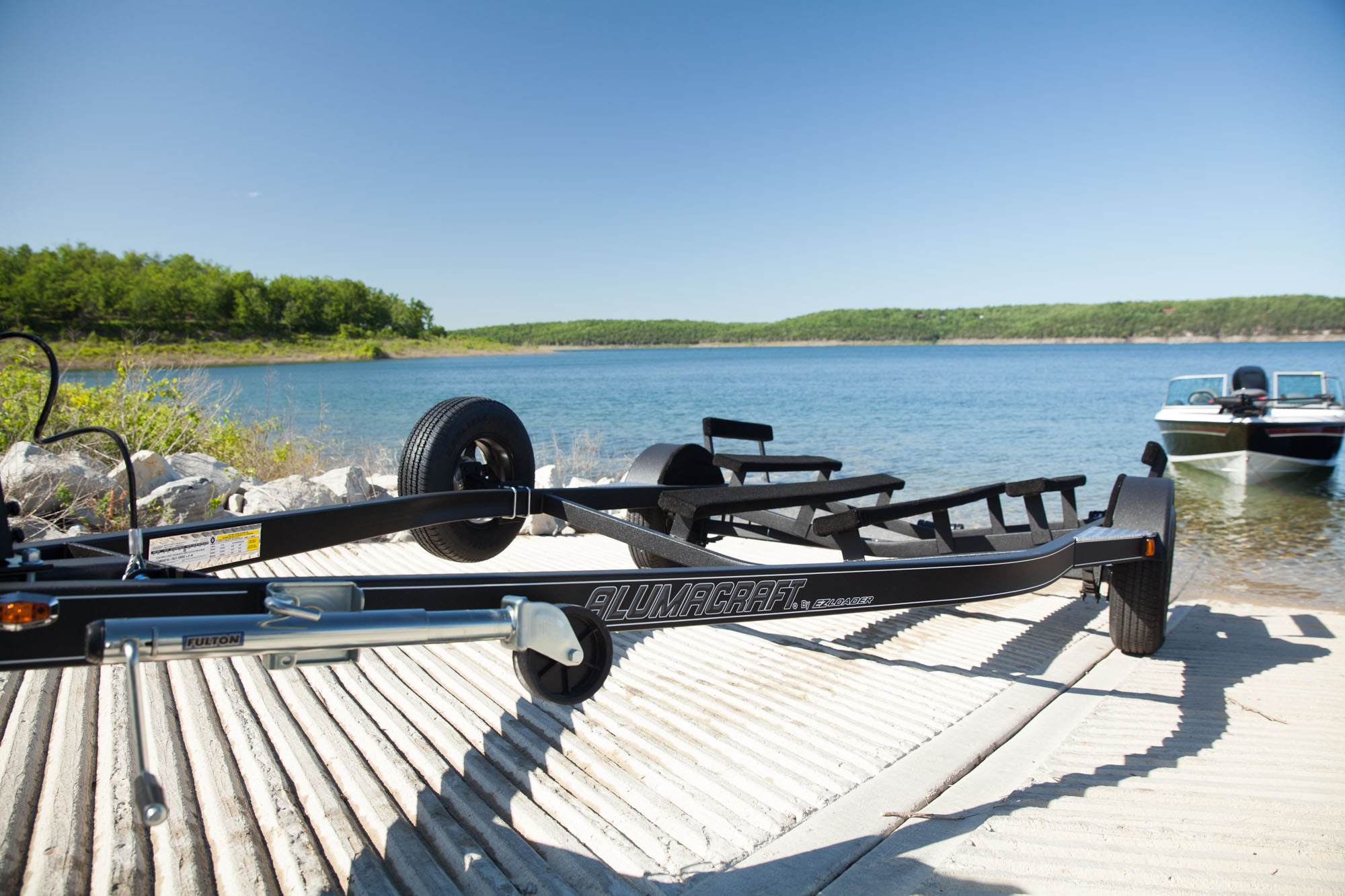 Custom black single axle V-hull boat trailer from EZ Loader, featuring a durable powder-coated steel frame and marine-grade carpeted bunks for reliable boat transport and easy loading.