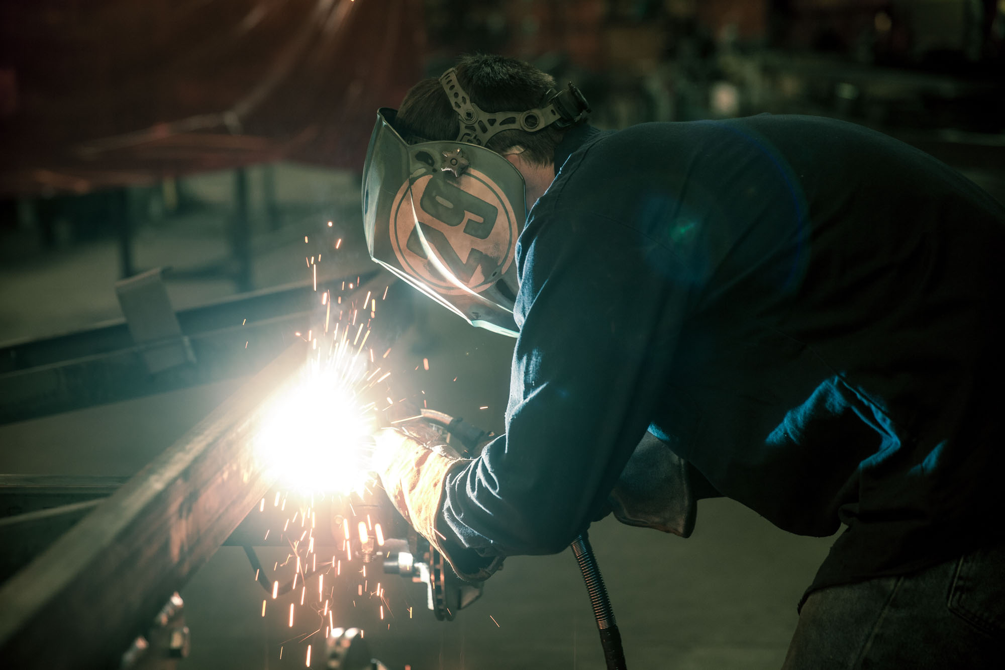 IMG_6739 Green boat launching onto an EZ Loader boat trailer at a shallow waterfront.