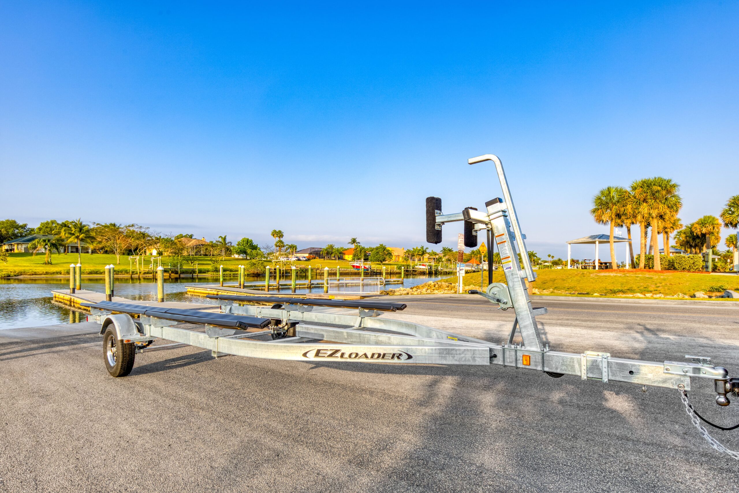 EZ Loader tandem axle black steel pontoon trailer with carpeted bunks, front boarding ladder, spare tire mount, and LED taillights