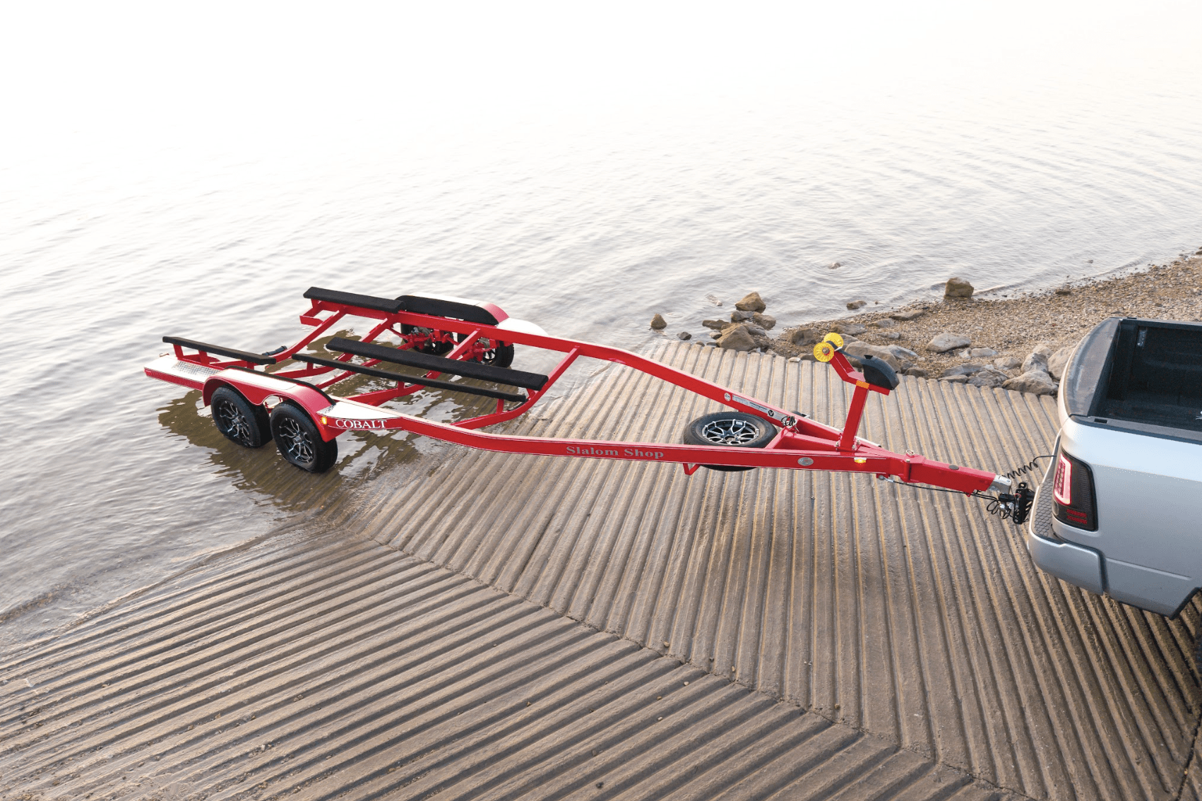 EZ Loader custom triple axle boat trailer with black powder-coated finish, diamond plate fenders, custom alloy wheels, and heavy-duty carpeted bunks designed for high-performance bass boats or tournament rigs.