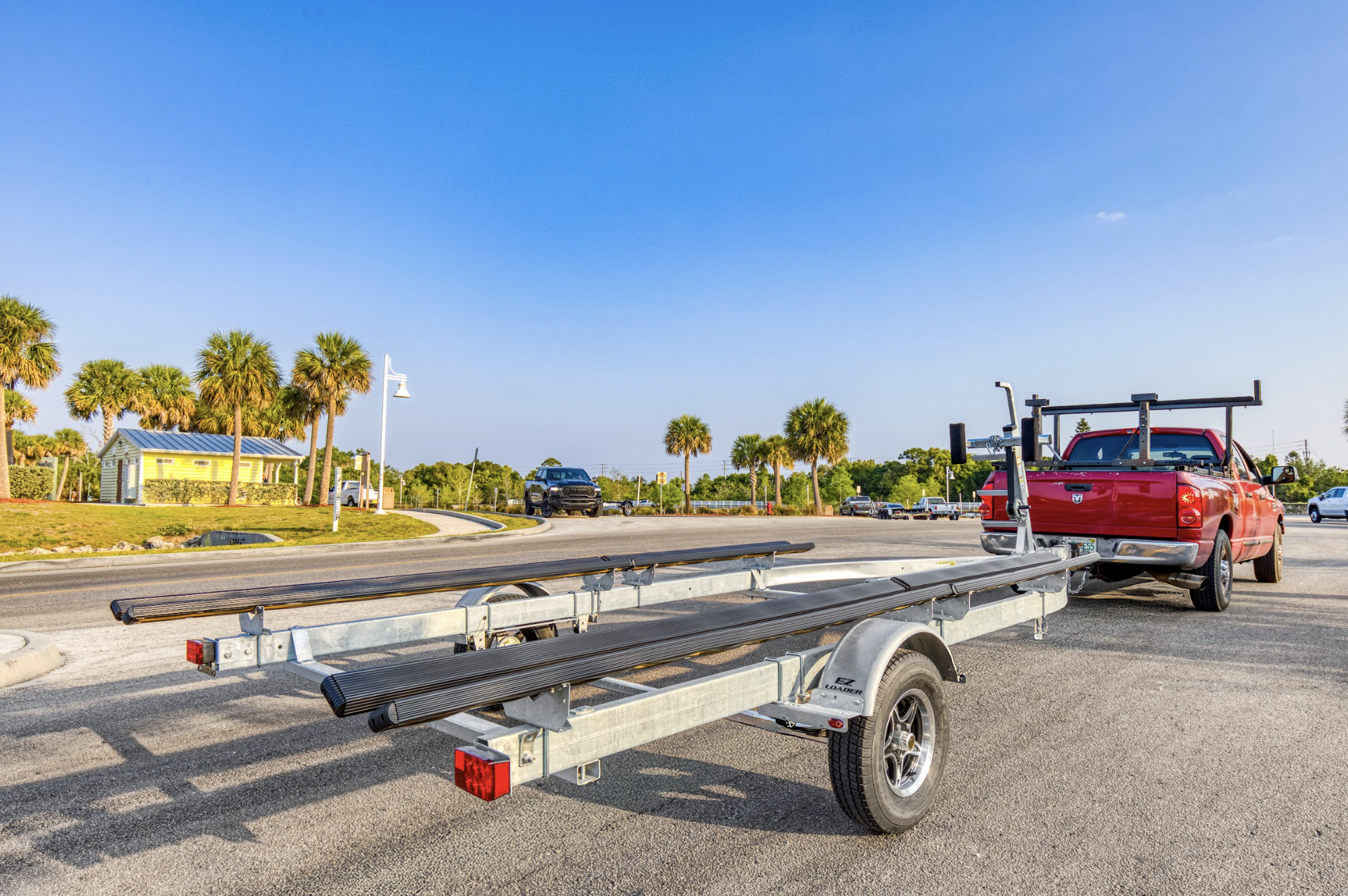 Single axle black EZ Loader pontoon trailer with custom bunk supports and winch post, built for stable and efficient pontoon boat transport.